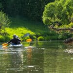 Family kayak trip for seigneur and senora. An elderly married couple rowing a boat on the river, a water hike, a summer adventure. Age-related sports, mental youth and health, tourism, active old age