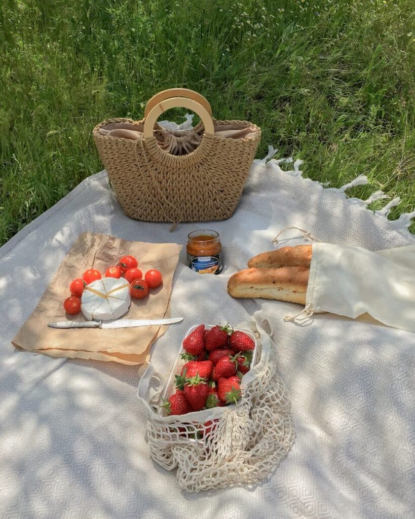 a picnic table with strawberries and bread